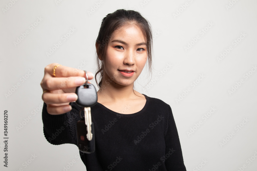Cute asian girl showing home residence keys. Cute asian girl showing home residence keys.