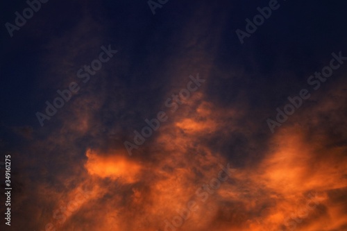 Burning sky, dramatic red colour clouds and sun ray shining through the heaven. God light and enigmatic powerful emotion. colour of nature. moody and aggressive atmosphere.