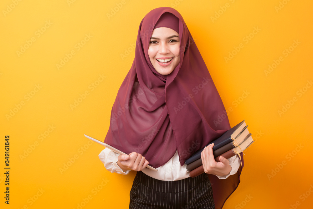 Beautiful University student with hijab portrait on yellow background Beautiful University student with hijab portrait on yellow background