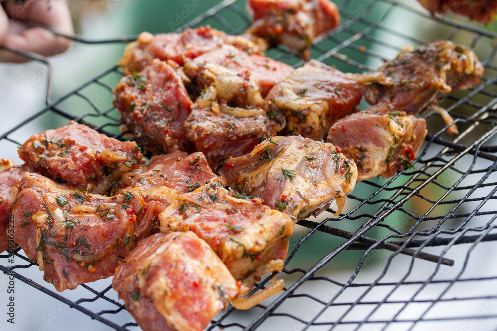Raw marinaded juicy pork meat in grill grates. Fresh food prepared for barbeque. Summer cooking outdoors