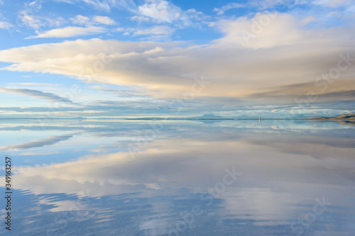 Misty landscape with clouds and reflection in the lake , early morning, calm and quiet, pastel blue and golden color, Salar de Uyuni, Bolivia