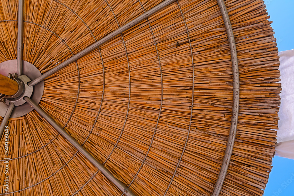 Big background of wooden straw umbrella on the beach