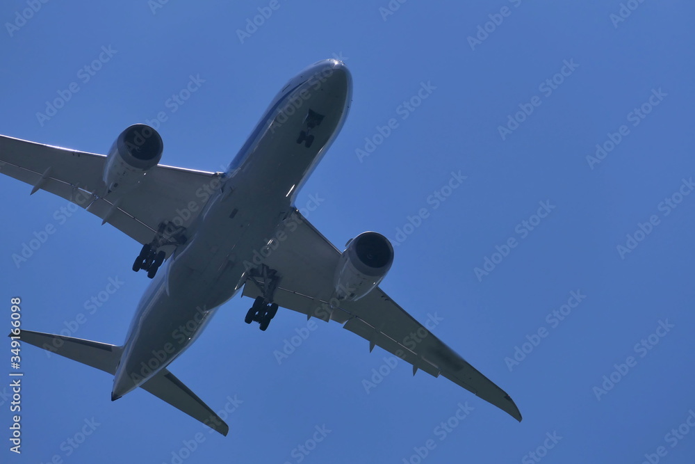 Fototapeta premium 青空の下着陸態勢の飛行機 