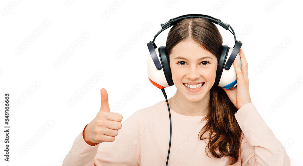 Hearing test. Positive girl in headphones during a hearing test, isolated on white. Audiometry Hearing test. Positive girl in headphones during a hearing test, isolated on white. Audiometry