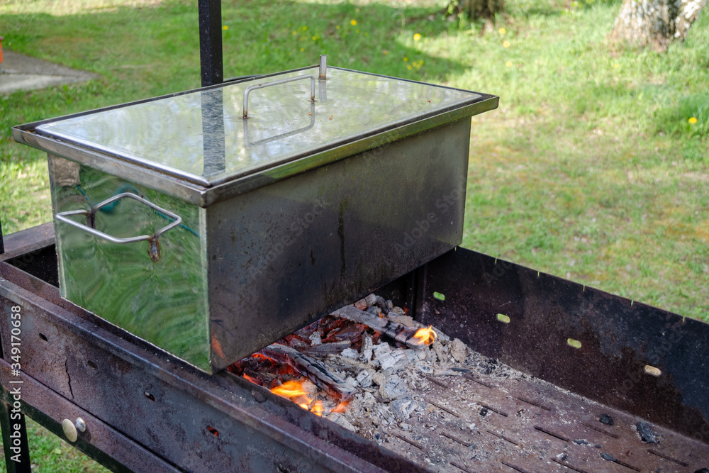 The smokehouse is on the grill. The process of cooking products outdoors. Cooking at the stake. The smokehouse is on the grill. The process of cooking products outdoors. Cooking at the stake.