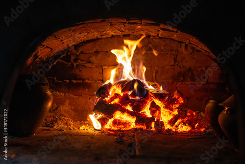 Village stove firewood and fire. Burning wood inside traditional oven