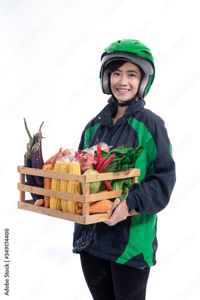 female uber delivery courier wearing helmet bring groceries in wooden crate female uber delivery courier wearing helmet bring groceries in wooden crate
