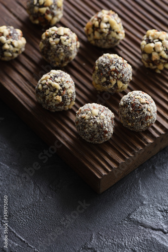 Healthy food concept. Homemade coconut energy balls on ribbed oak board on black background angle view