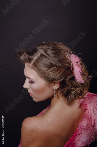 The beautiful girl in a beautiful pink dress on black background