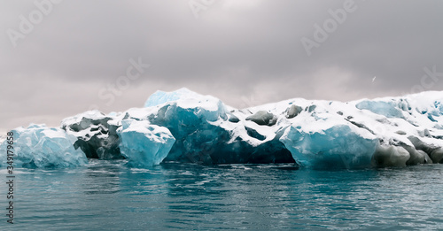Multi-colored floating glacial ice with snow cover. Antarctic Peninsula