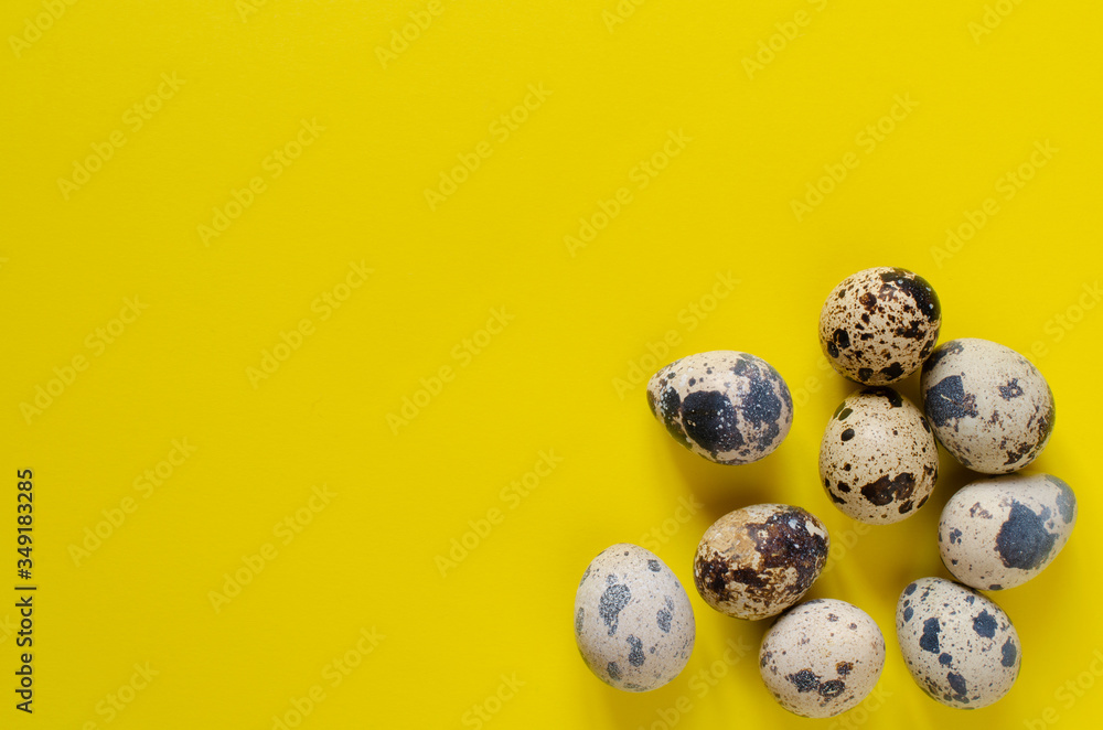 organic quail eggs on yellow background with copy space.