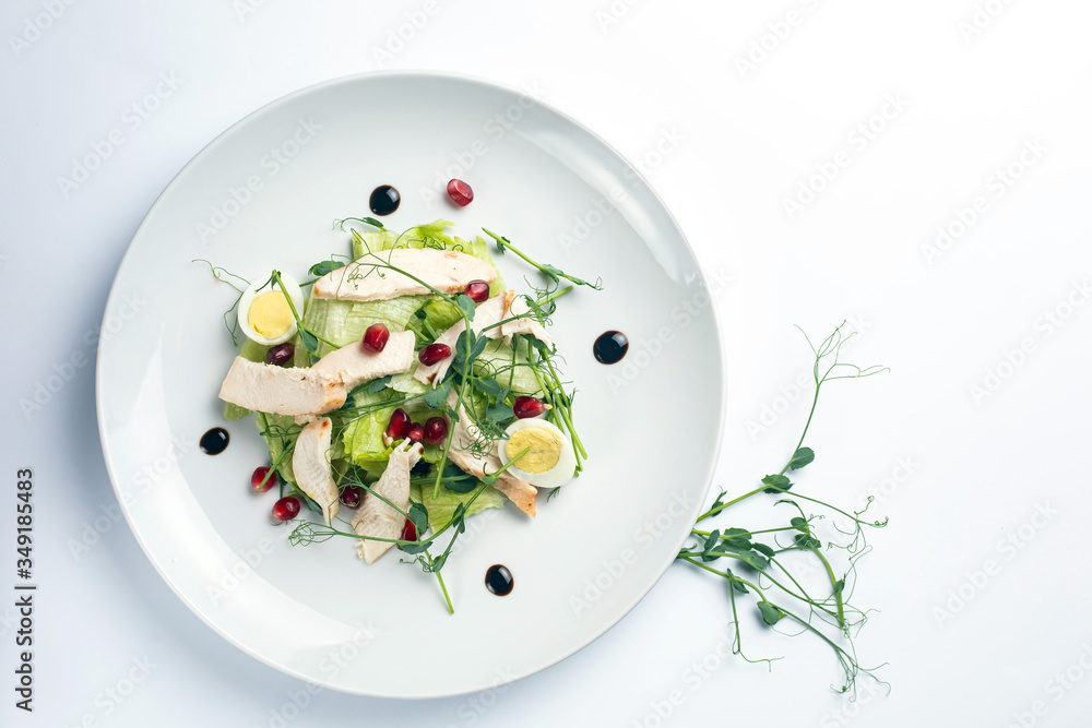 fresh salad with chicken, eggs and vegetables on a white background fresh salad with chicken, eggs and vegetables on a white background
