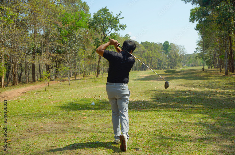 Golfer addressing the ball as he is about to tee off with a driver on a short four par. Golfer addressing the ball as he is about to tee off with a driver on a short four par.
