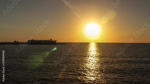 Atardecer frente al muelle de CEPA El Salvador Acajutla cielo despejado colores del sol reflejo en el mar photo