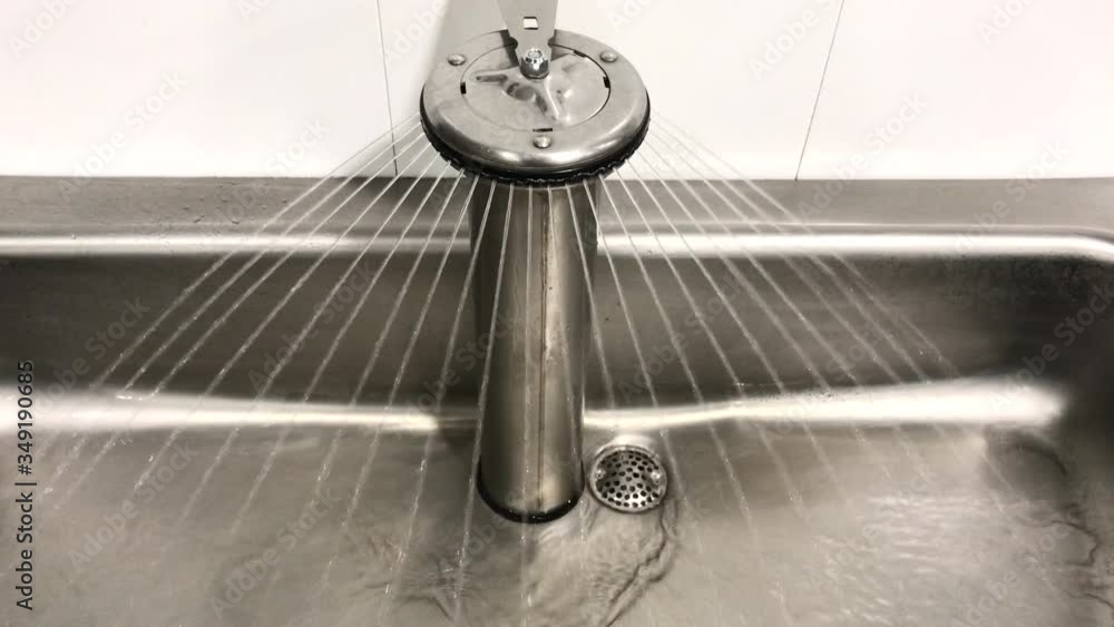 Industrial hand washing station with running water. Water running in a commercial handwashing