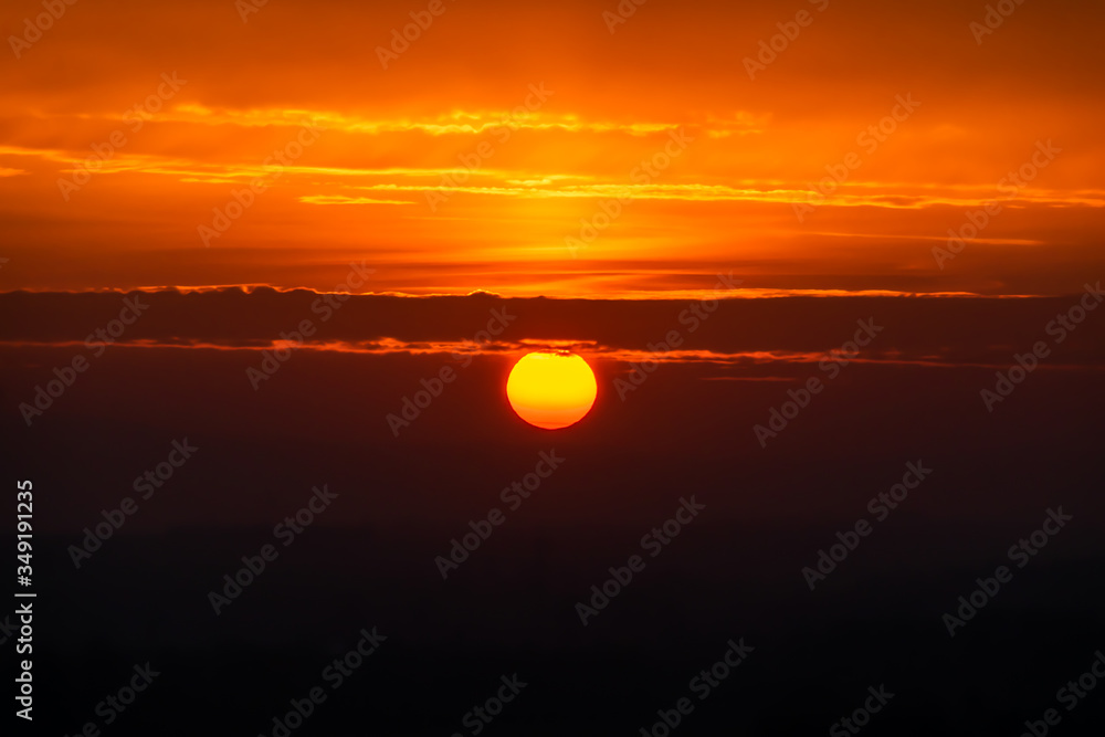 Fototapeta premium Sonnenuntergang mit großer Sonne und Wolken