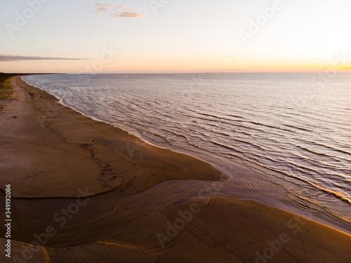 Amazing evening aerial flight along sunset beach with beautiful waves
