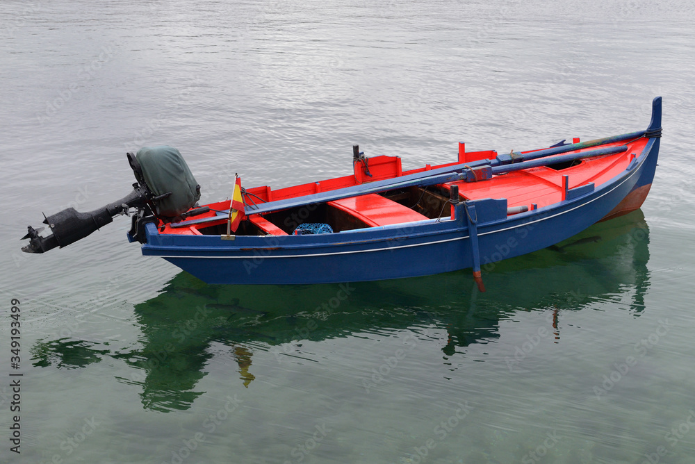 wooden fishing boat with motor moored in the sea
