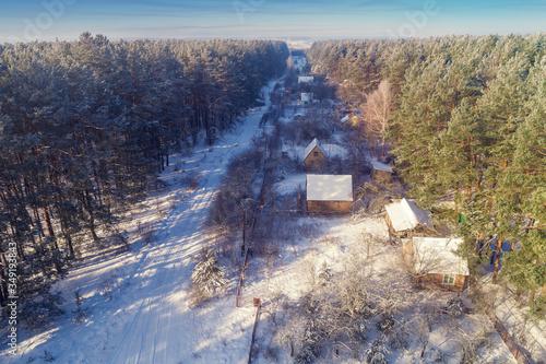 View from above of village lokated in pine forest in snowy winter photo