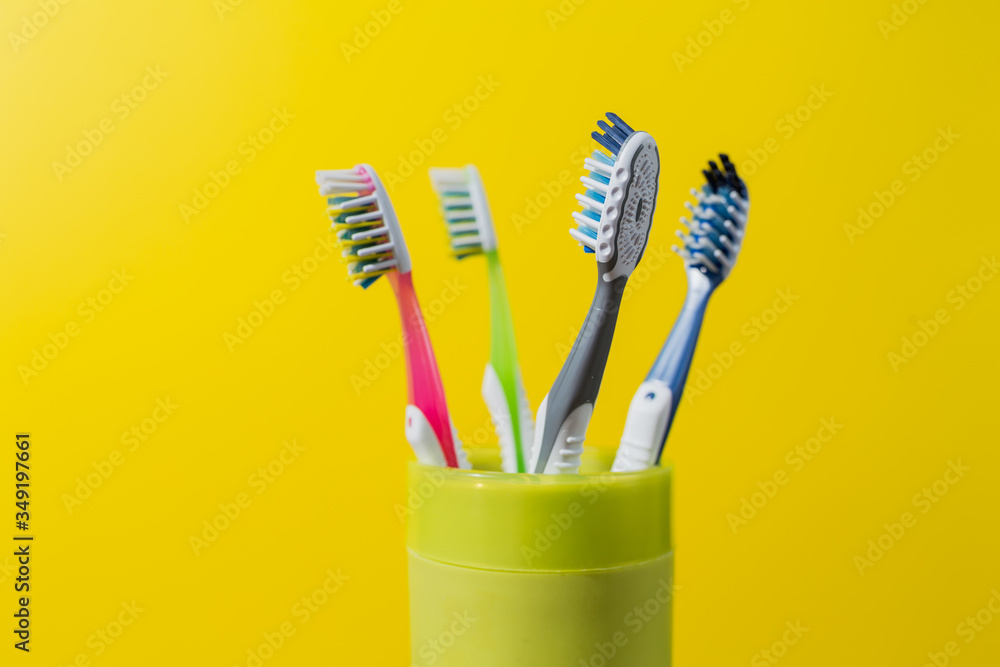 four toothbrushes in a green glass four toothbrushes in a green glass