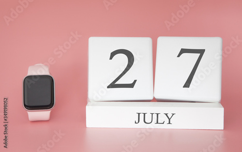 Modern Watch with cube calendar and date 27 july on pink background. Concept summer time vacation.