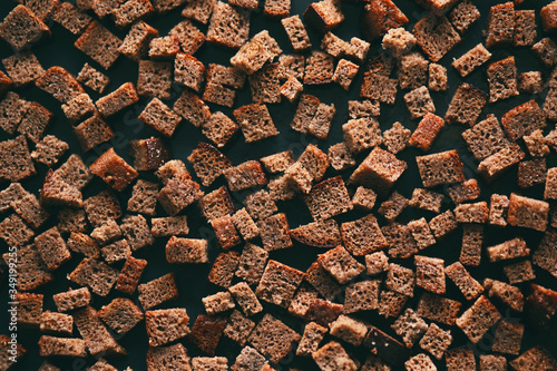 Tableau sur toile Cut into cubes, rye bread is placed on a dark baking sheet,  it is sent to the oven and it will become crackers