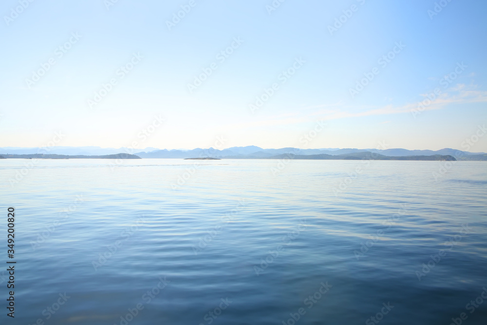 View over the calm ocean looking towards the horizon with pale pastel shades of blue, turquoise & white, off the coast of Stavanger, Rogaland county, Norway.