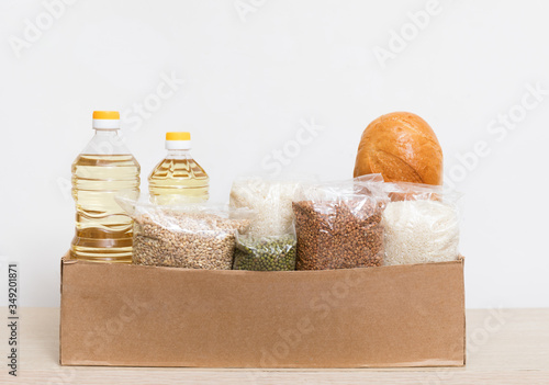.help those who need food. Donation box with vegetable oil, cereals, bread on a white background.