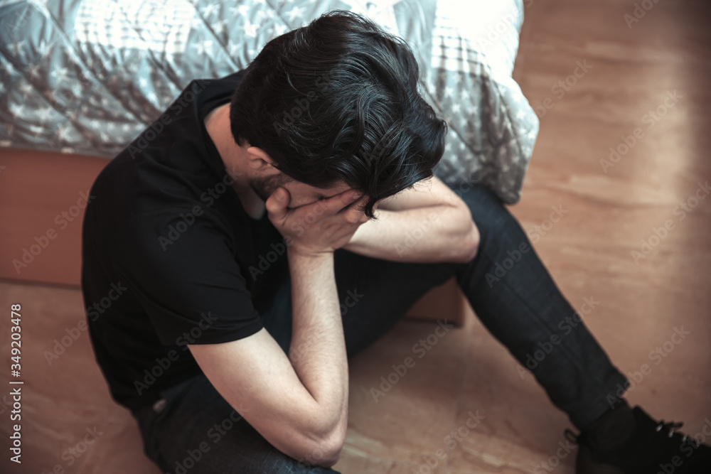 sad man sitting in room sad man sitting in room