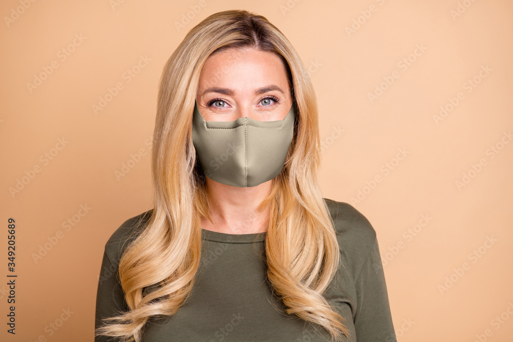 Portrait of cheerful cute nice pretty mature woman looking stay home covid-19 quarantine in white breathing protective mask isolated pastel beige color background Portrait of cheerful cute nice pretty mature woman looking stay home covid-19 quarantine in white breathing protective mask isolated pastel beige color background