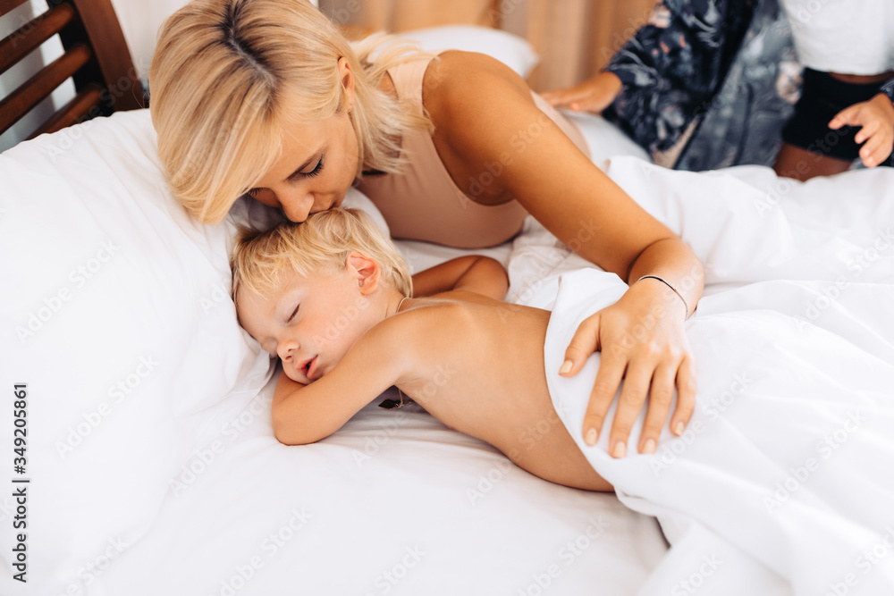 Mom kisses her sleeping baby on vacation during an afternoon nap Mom kisses her sleeping baby on vacation during an afternoon nap