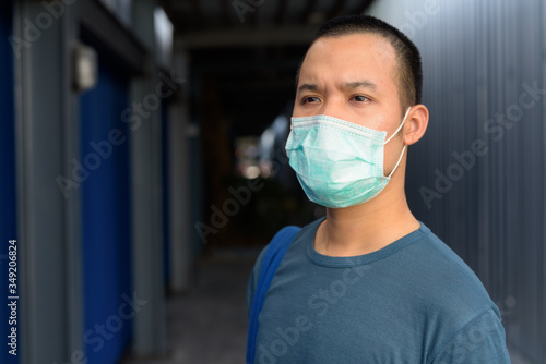 Face of young Asian man in the city outdoors