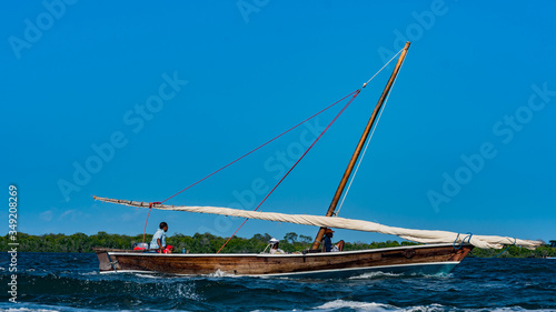 A traditional Arab dhow with a sail down but being propelled with a motor engine in Lamu Island