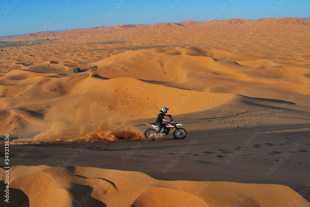 Riding motorbike in desert dunes