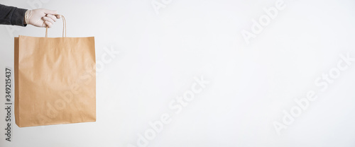 Slika na platnu Concept of delivery - Hand of a man holding an empty paper bag with products del