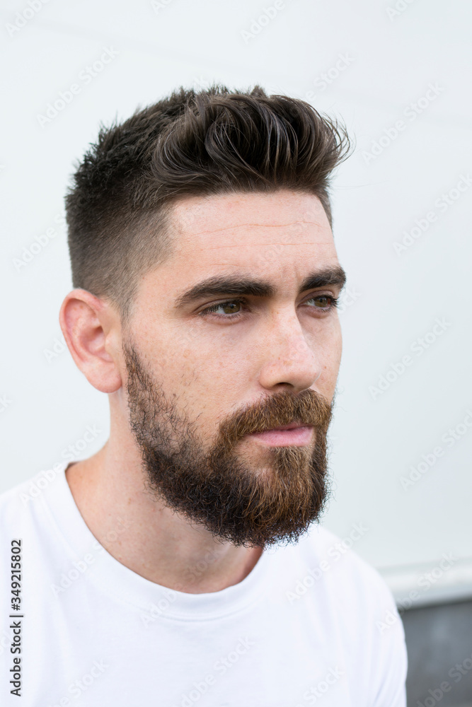 Fototapeta premium Portrait of a very handsome Caucasian man with a beard and white shirt.