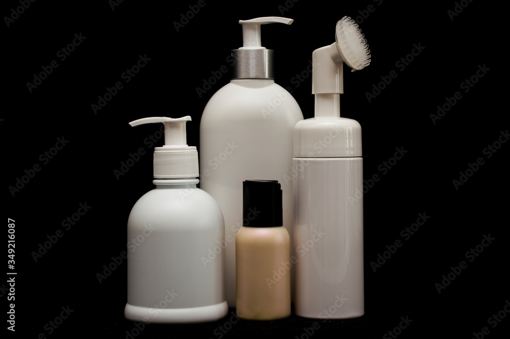 white plastic cosmetic bottle on black background white plastic cosmetic bottle on black background