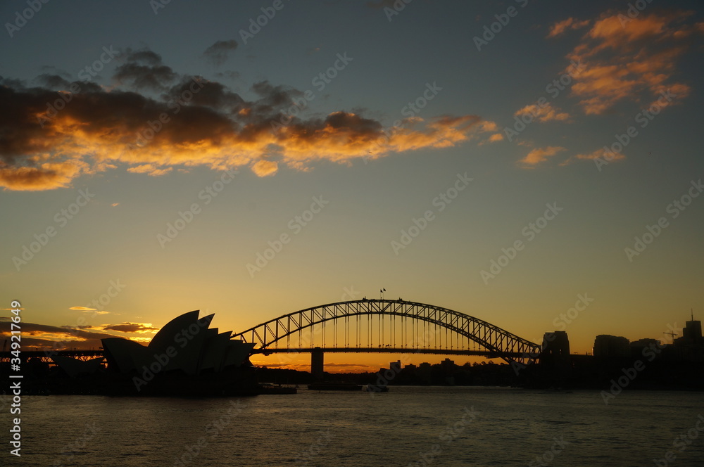 Naklejka premium sydney harbour bridge and opera house at sunset