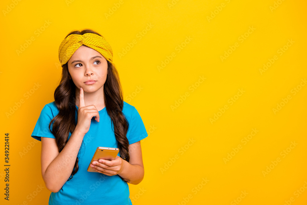 Photo of beautiful little lady hold telephone quarantine time stay home finger on chin writing new blog post for pupils wear casual blue t-shirt headband isolated yellow color background Photo of beautiful little lady hold telephone quarantine time stay home finger on chin writing new blog post for pupils wear casual blue t-shirt headband isolated yellow color background