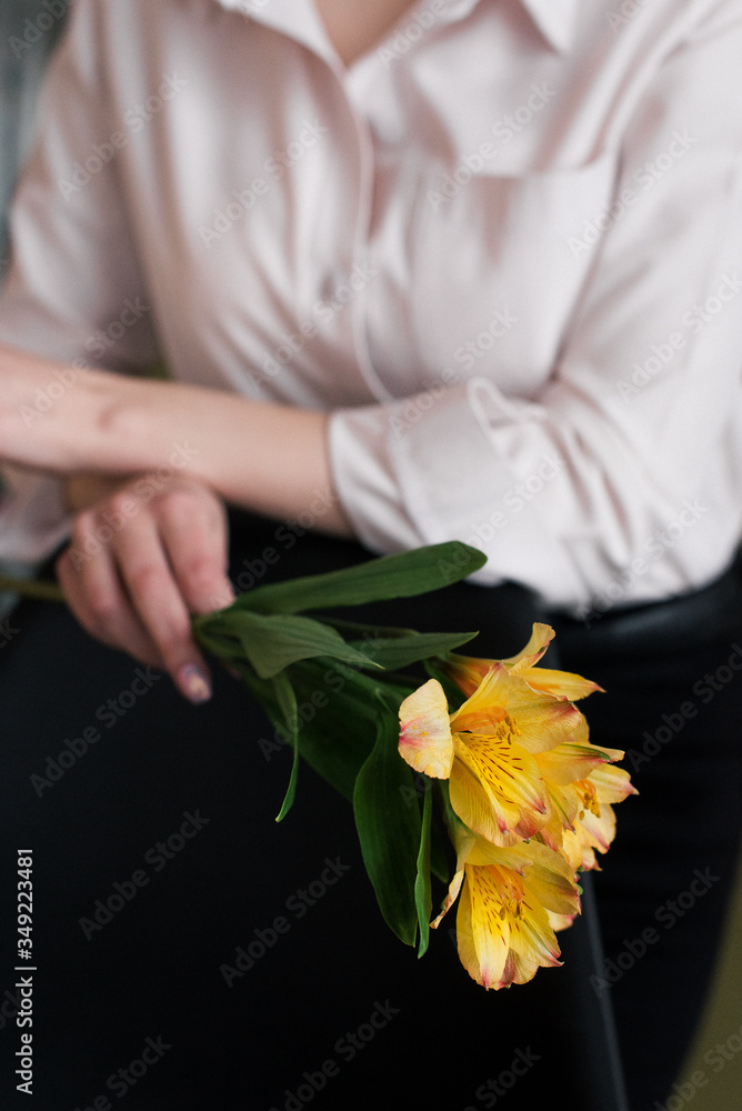 The girl touches a yellow flower. Girl and flower. A yellow flower in a girl's hand. 