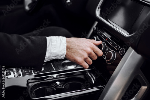 Businessman changing turning button radio stations on his automobile © Monako Art Studio