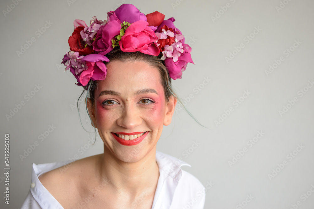 Sensual woman in floral wreath. Portrait of beautiful young woman with red lips dressed in a white blouse. Sensual woman in floral wreath. Portrait of beautiful young woman with red lips dressed in a white blouse.