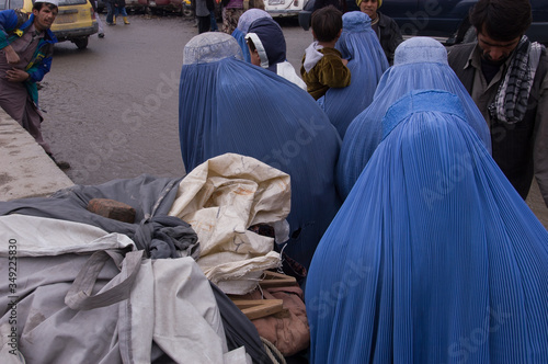Kabul, Afghanistan - March 2005: women in burqas walking throguh Kabul streets photo