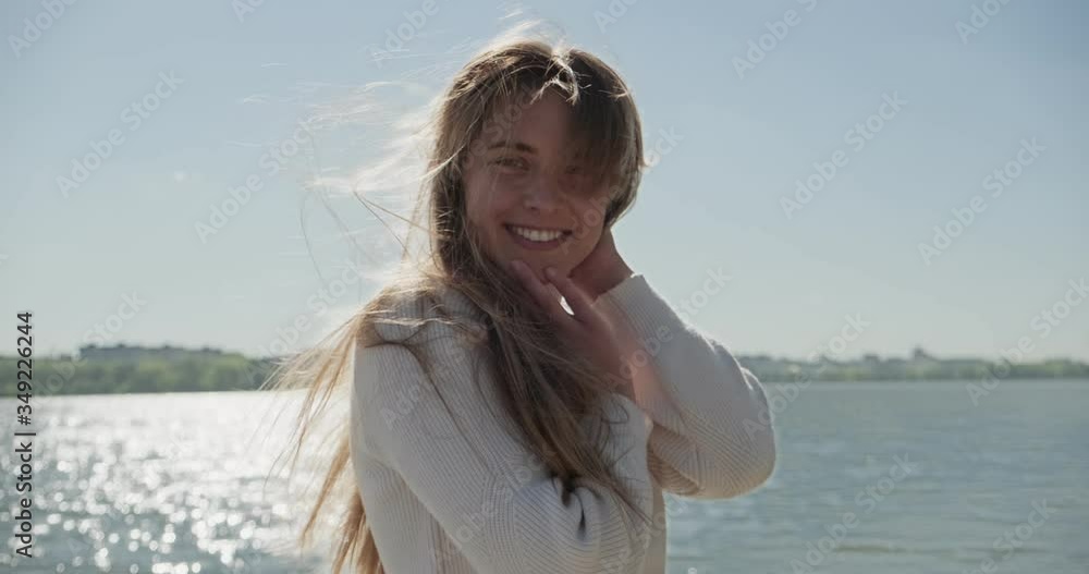 Portrait of young attractive female who smiling and looking at the camera. Cheerfully pretty woman near lake at sunny weather. Close up Portrait of young attractive female who smiling and looking at the camera. Cheerfully pretty woman near lake at sunny weather. Close up