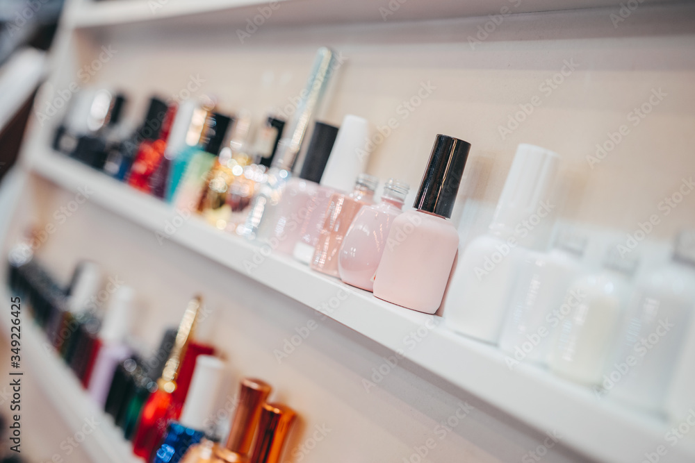 Various Bottles of nail polish on white shelf on shop. Group of bright nail polishes. Set of different nail varnishes on shelves in cosmetic store Various Bottles of nail polish on white shelf on shop. Group of bright nail polishes. Set of different nail varnishes on shelves in cosmetic store