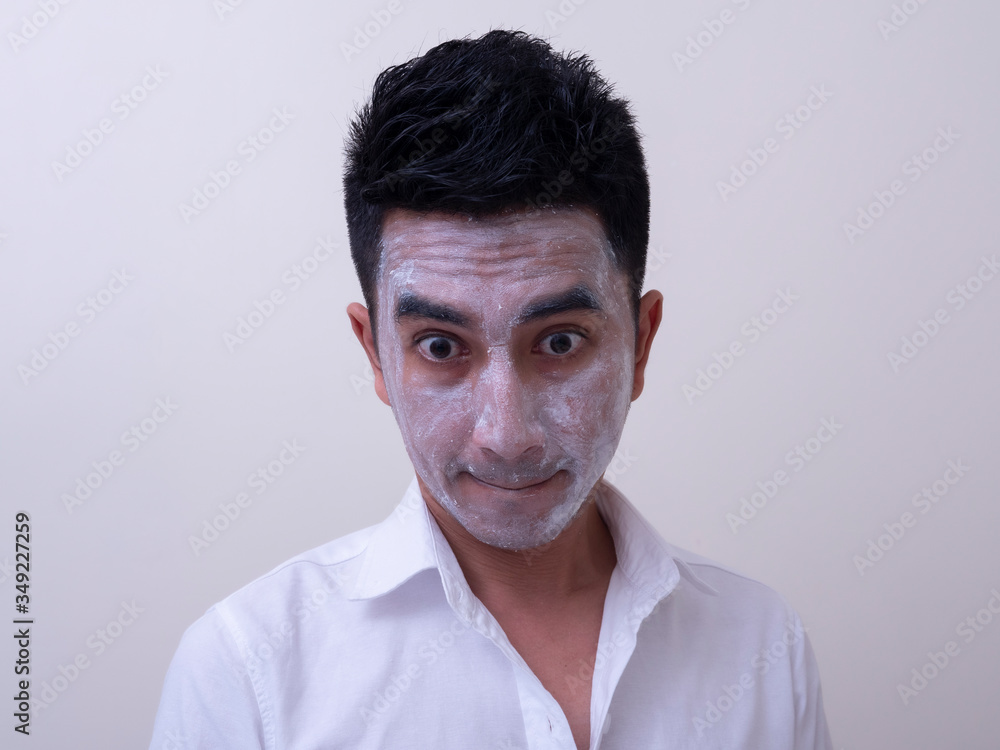 Asian handsome young man applying cream at his face with smiley face, Skin care concept