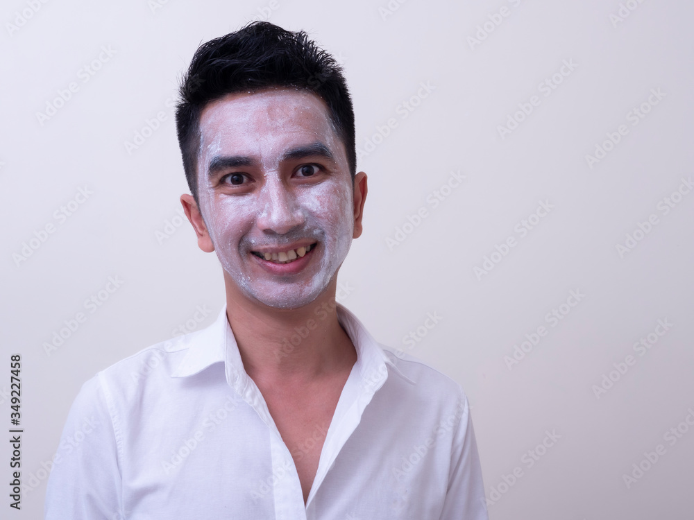 Asian handsome young man applying cream at his face with smiley face, Skin care concept Asian handsome young man applying cream at his face with smiley face, Skin care concept