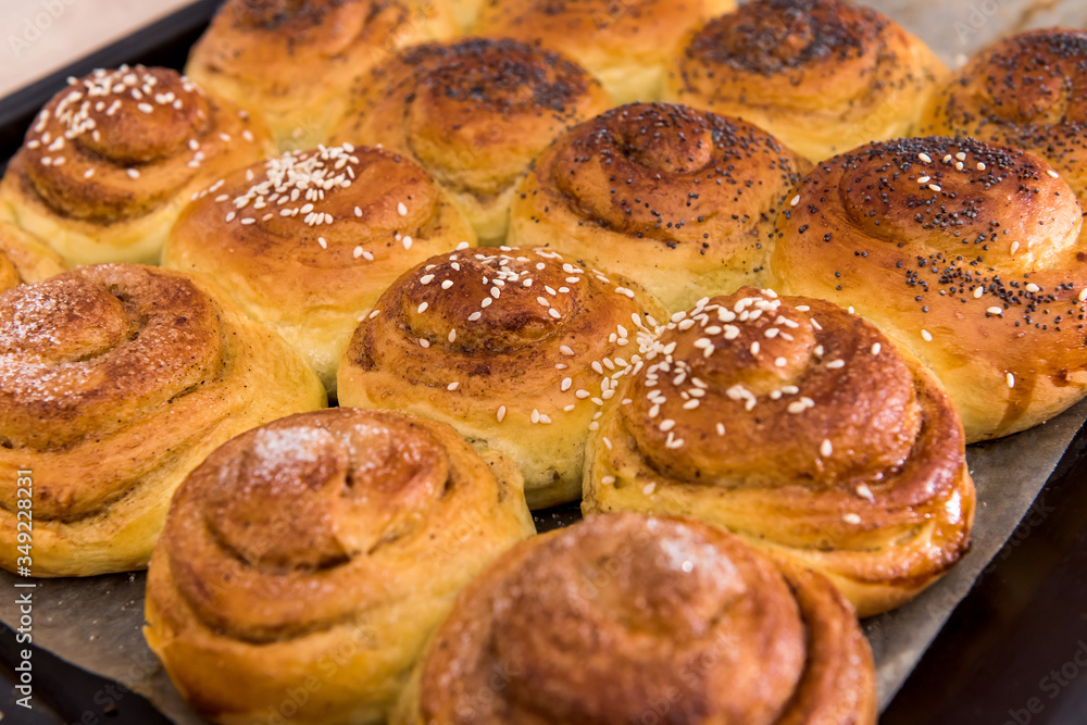 delicious buns baked with poppy seeds on a tray