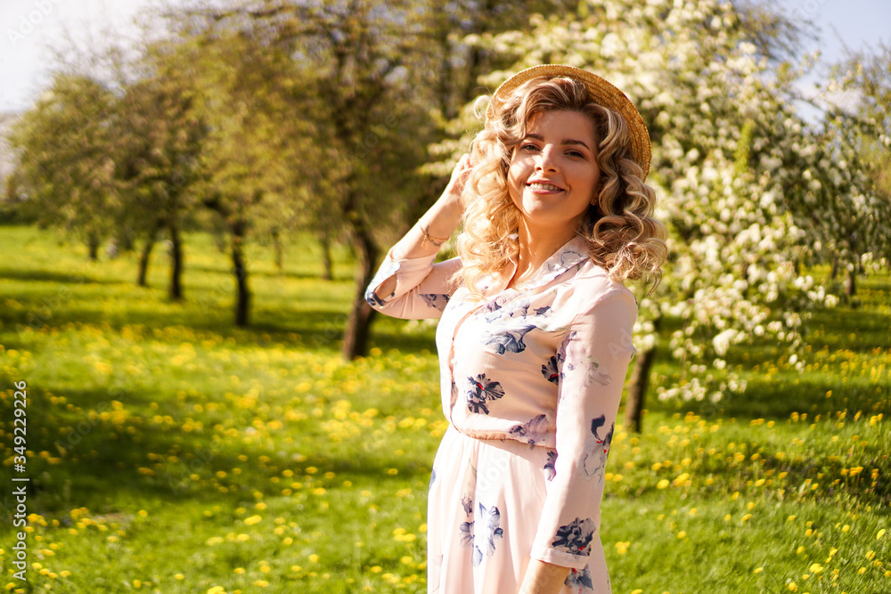 Smiling summer woman with straw hat in park - apple garden in spring sunny day Smiling summer woman with straw hat in park - apple garden in spring sunny day