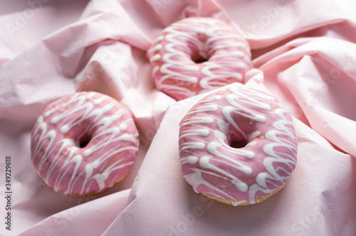 Pink glaze decorated donuts on wavy pink background
